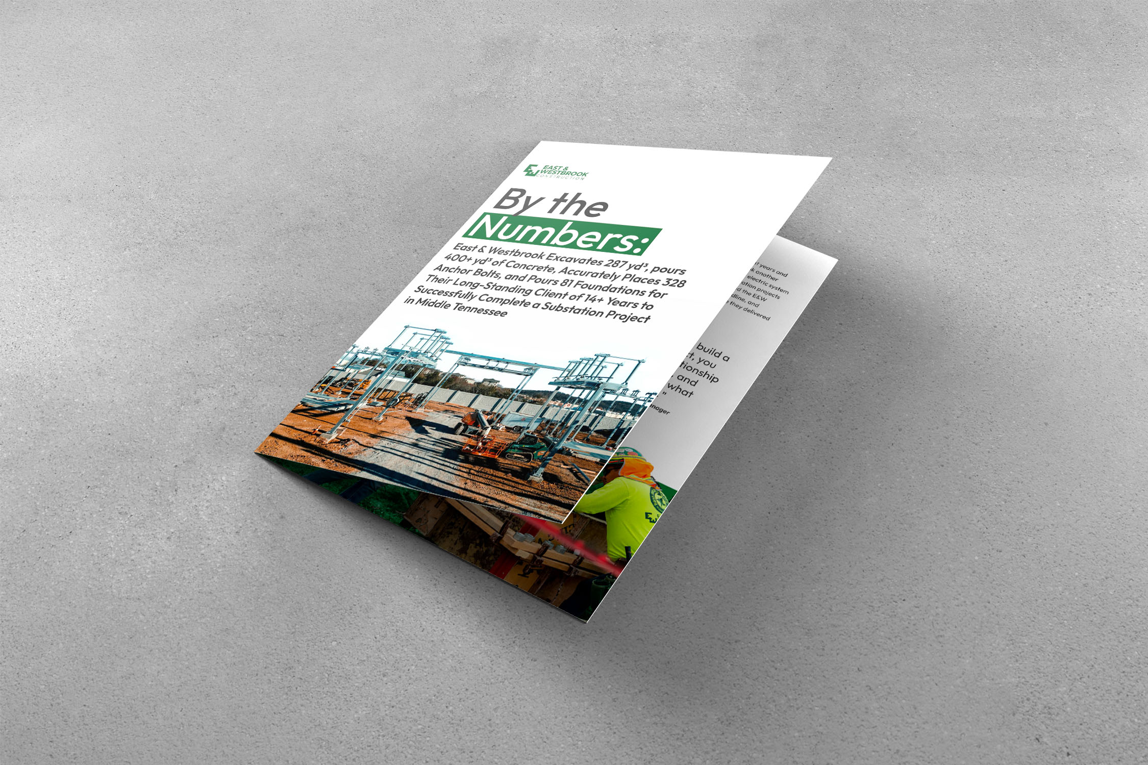 Folded brochure on a gray surface showing a substation construction site and text detailing excavation and concrete work statistics.