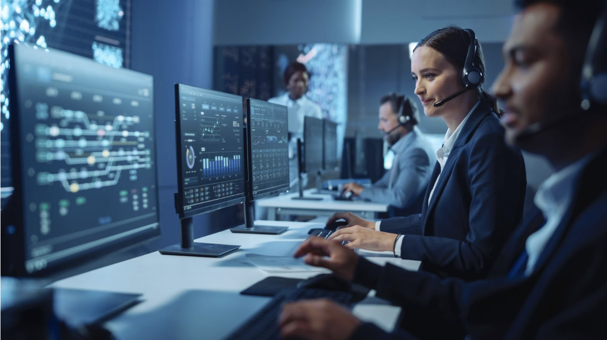 Woman providing IT support in a room with IT professionals