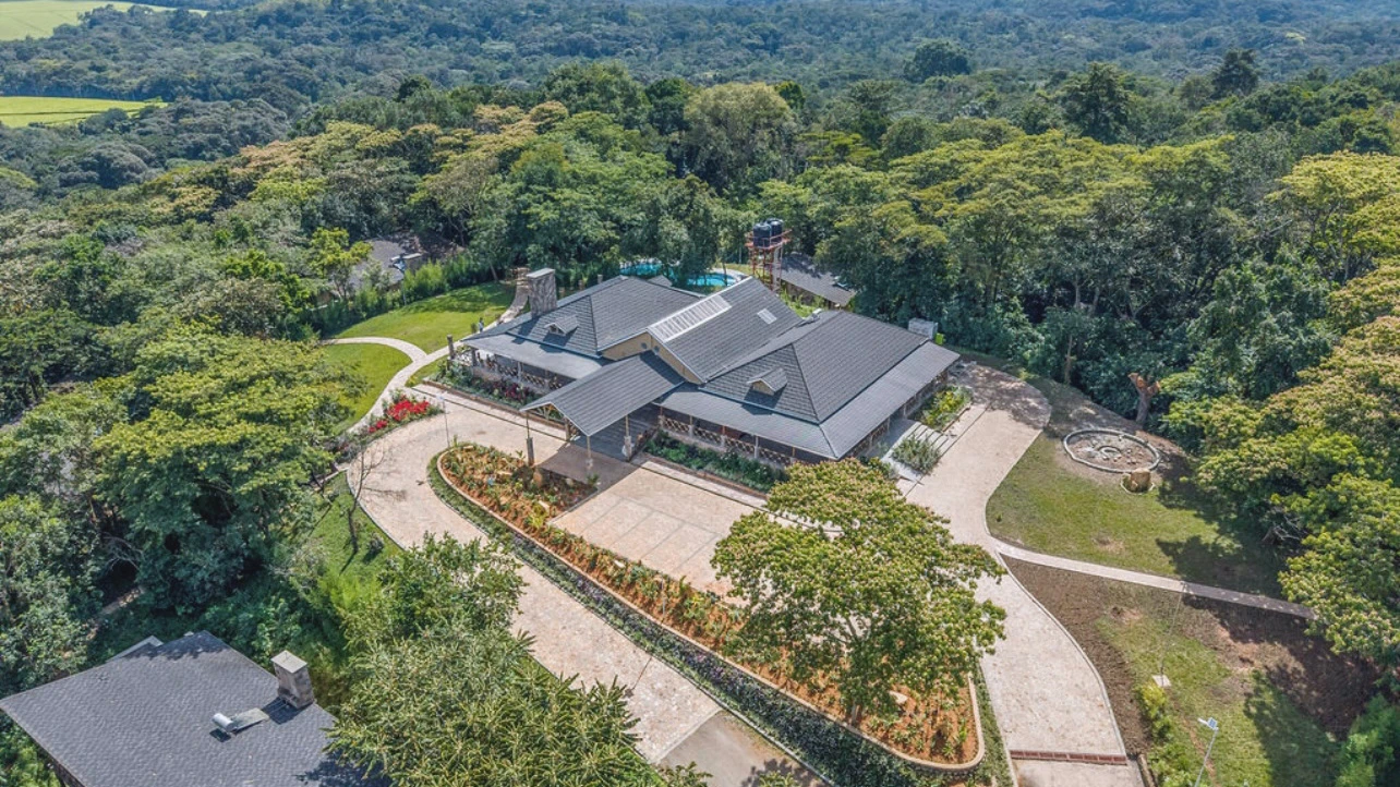 Aerial view of a large modern eco-lodge surrounded by dense green forest and landscaped gardens. Kalinzu Eco Lodge Construction Project by Elevate Holdings Limited.