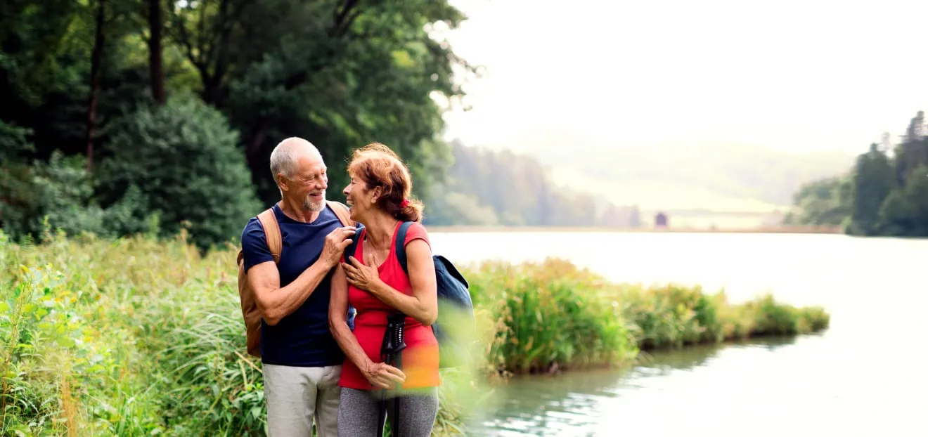 Bandscheibenvorfall Sport welche Sportarten - Mann und Frau beim Wandern am See nach einem Bandscheibenvorfall