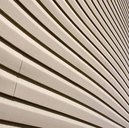 Close-up of vinyl siding with a cracked panel and uneven surface