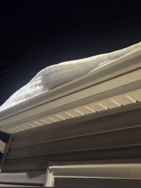 Heavy snow accumulation along the roofline and gutters of a Columbus, Ohio home during winter.