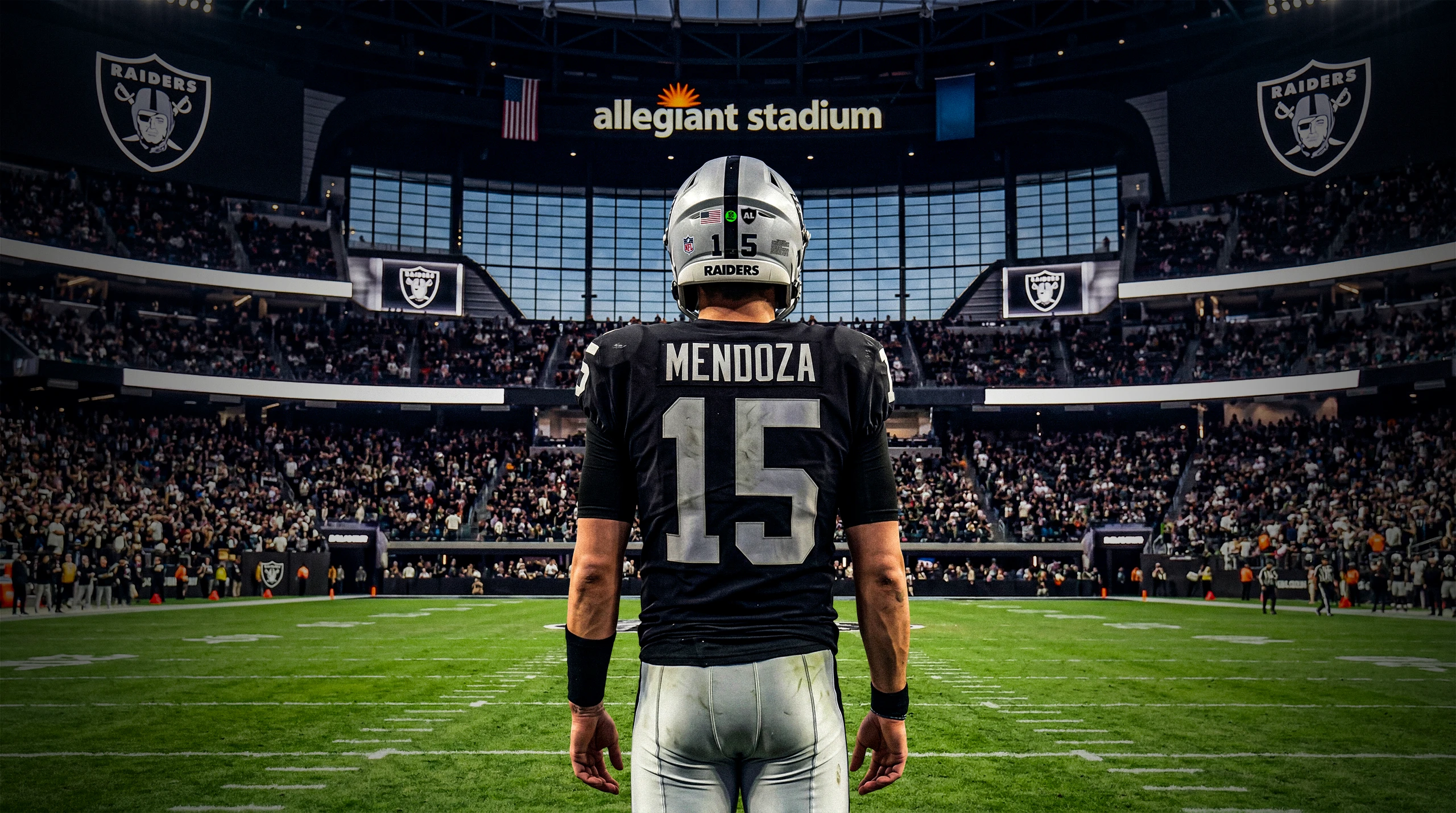 Football player Mendoza number 15 in Raiders uniform standing on the field at Allegiant Stadium with a crowd in the background.