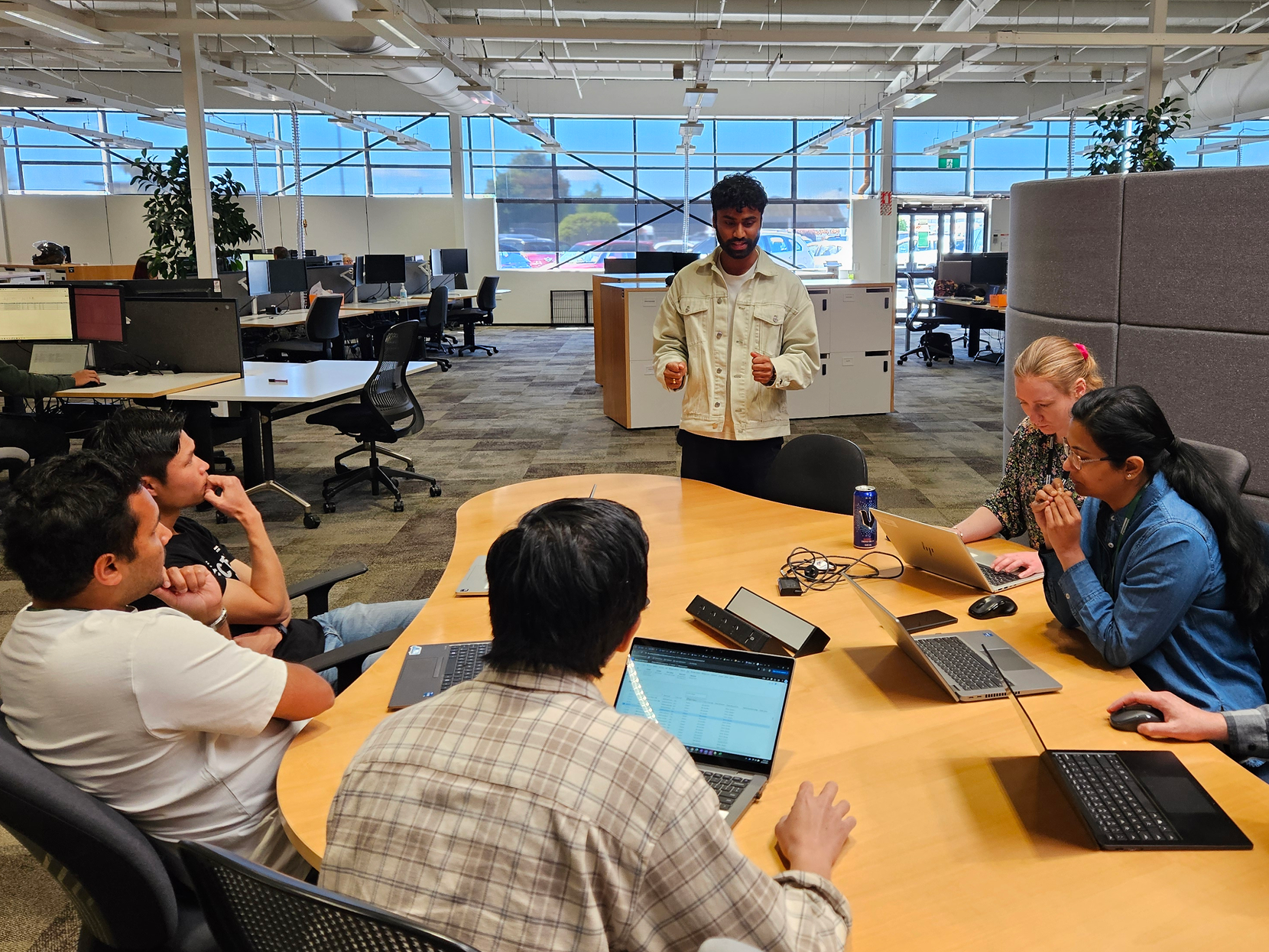 Man standing in front of a group around a table