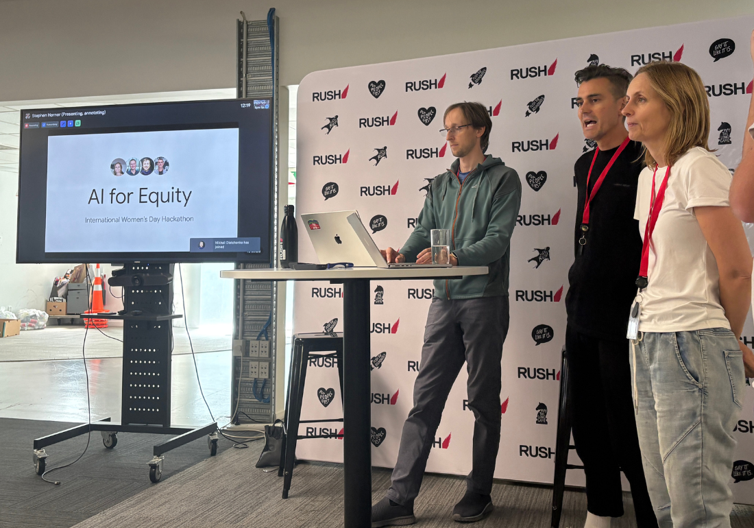 Three people standing in from of a screen which ays AI for Equity