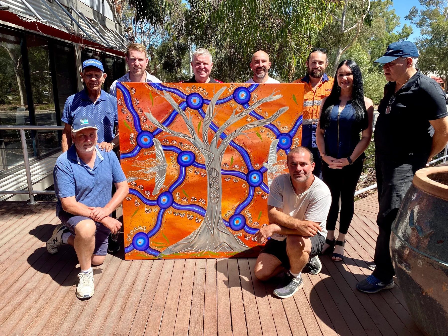 QA Electrical team with artist Simone Thomson around her painting Shield Tree