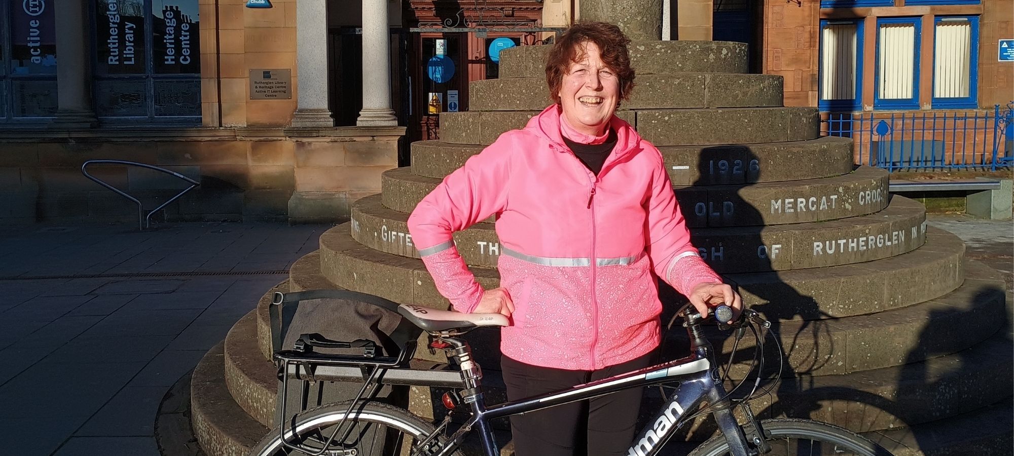 lady standing with a bike with a library in the background