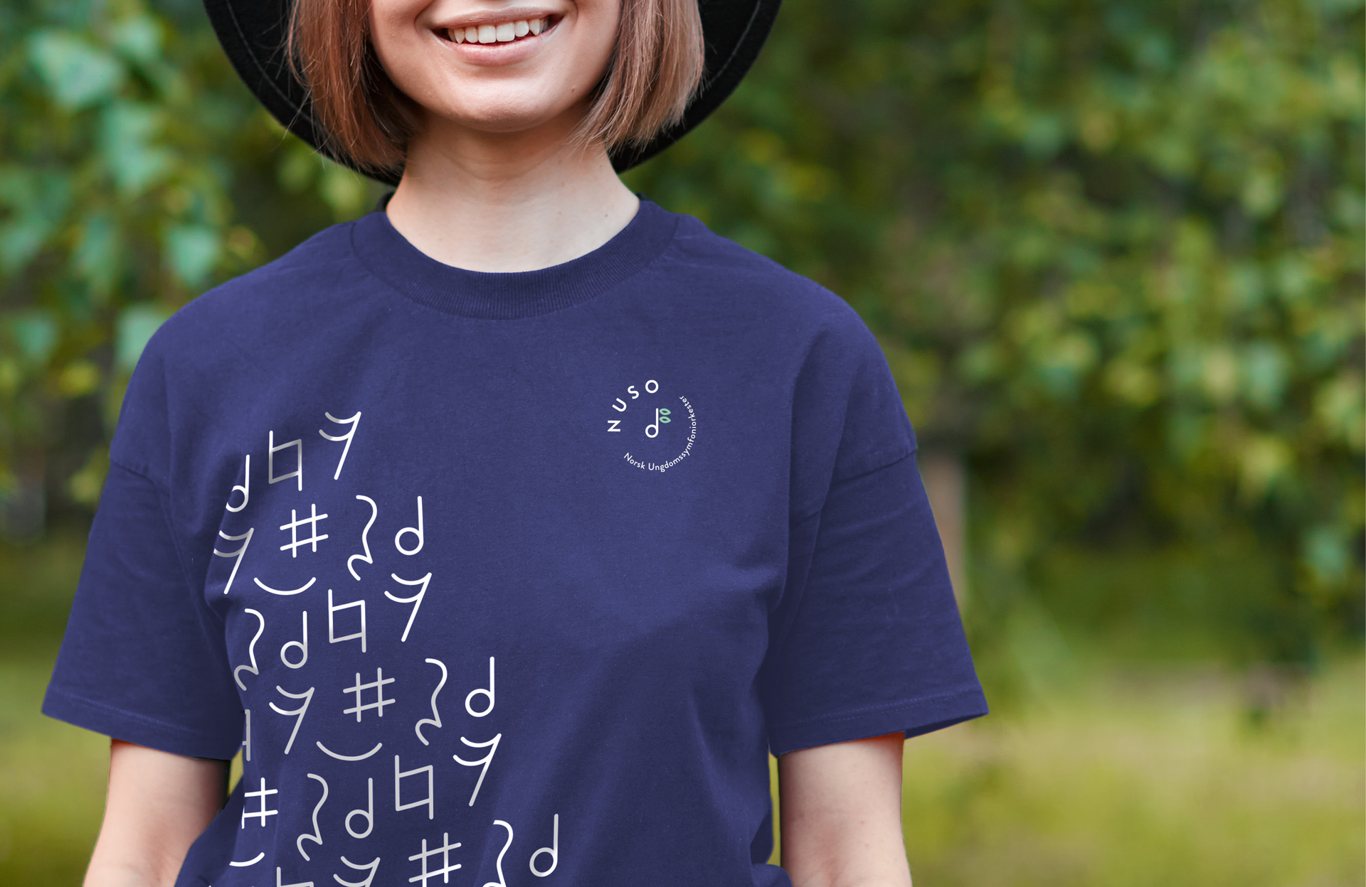 A woman wearing a purple NUSO shirt and a black hat.