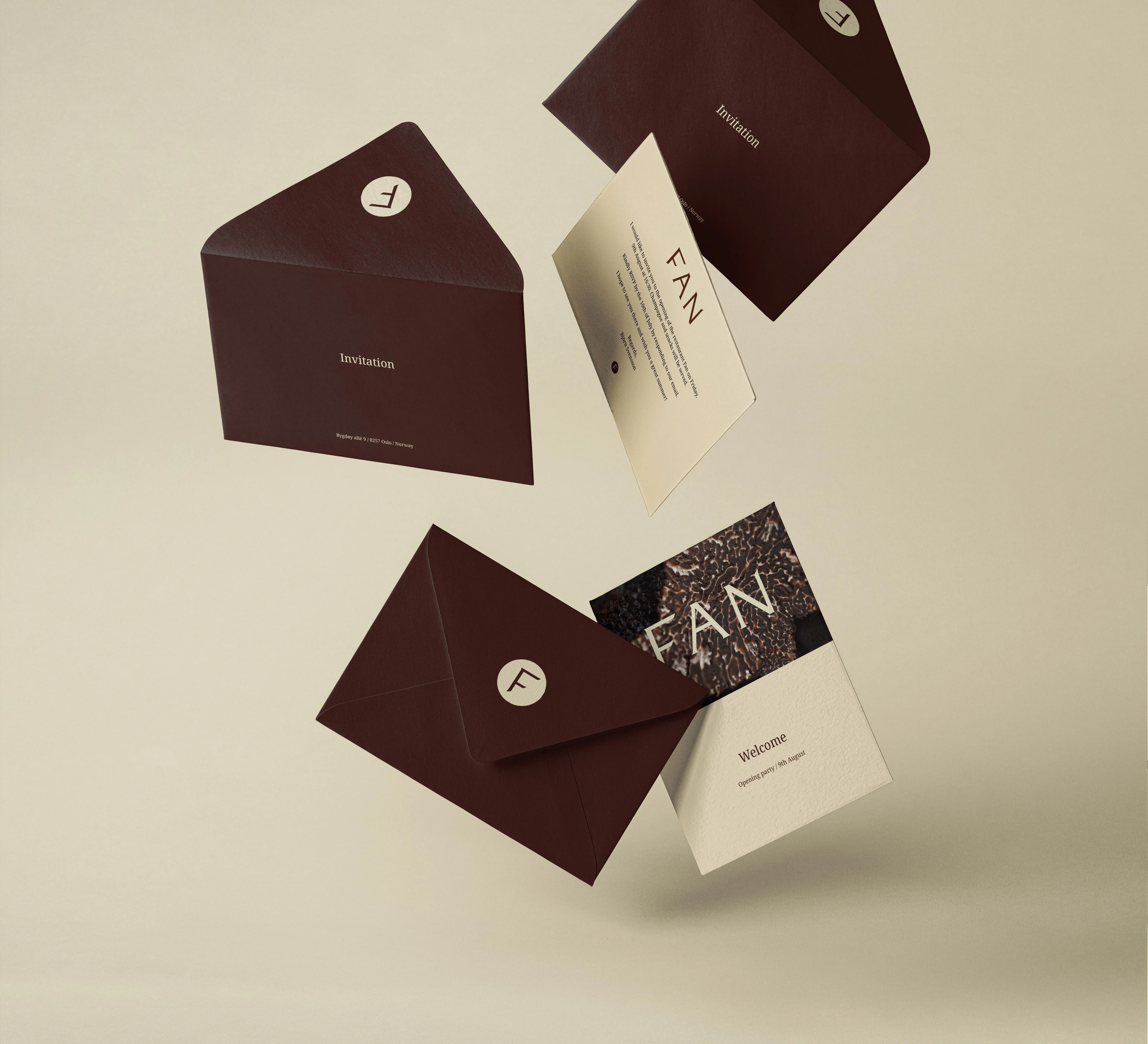 Dark brown envelopes and beige invitation cards with 'FAN' text and decorative design floating on a beige background.