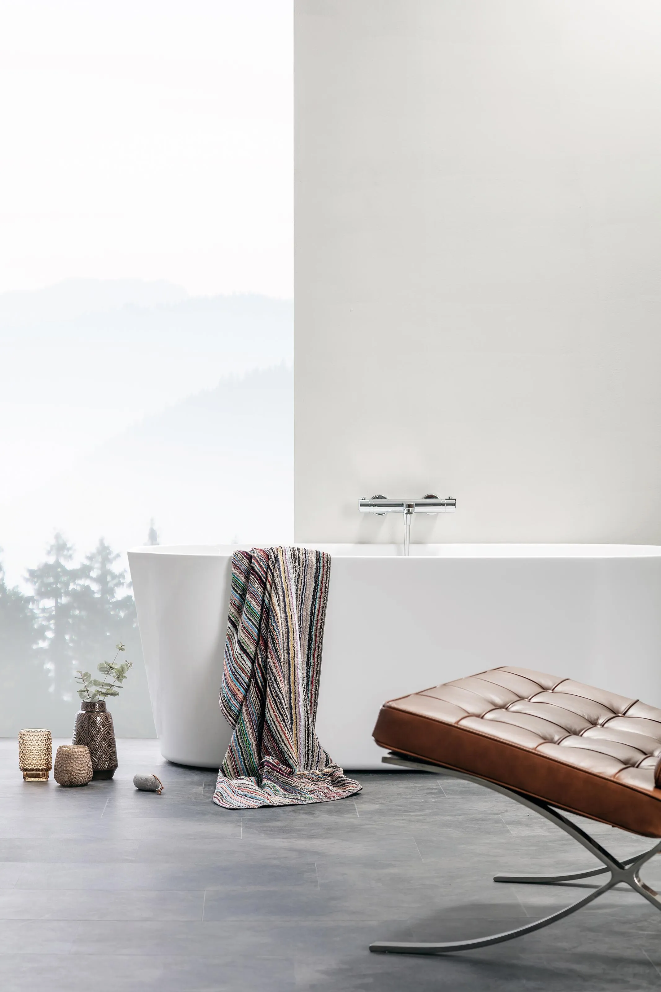 Contemporary minimalist bathroom featuring Alterna wall-mounted mirror cabinet in light oak frame, white vanity unit with integrated wood drawers, polished chrome mixer tap, white subway tiles, and grey terrazzo floor tiles.