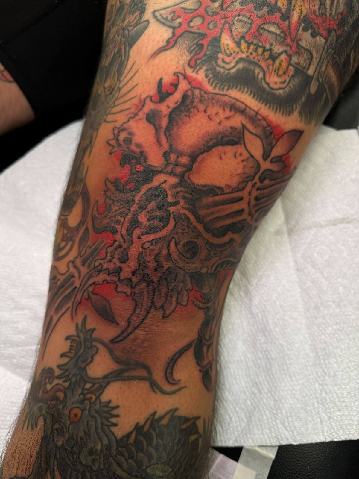 Black and grey fanged bio-mechanical skull tattoo