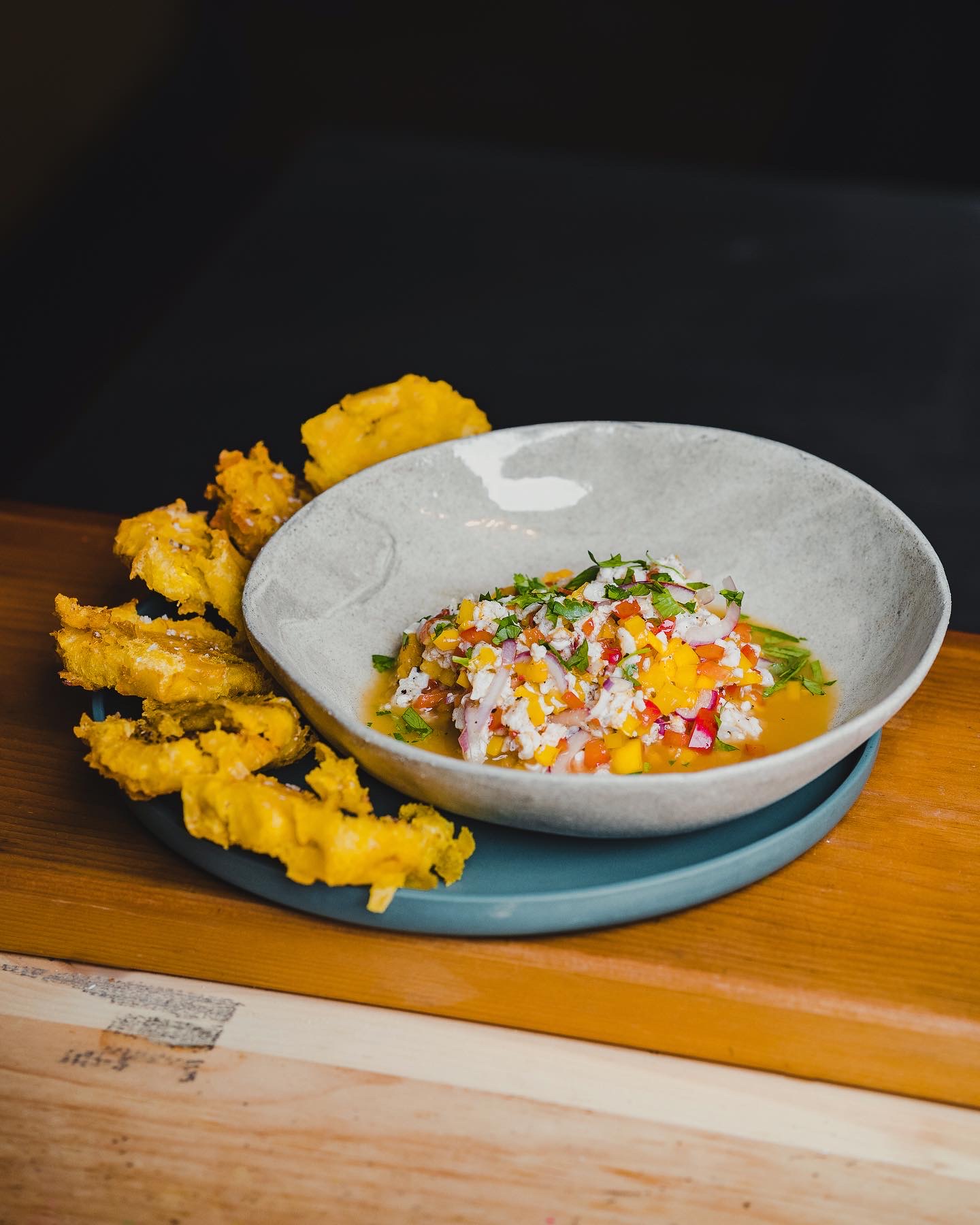 A legume salad in a bowl with plaintains on the side.