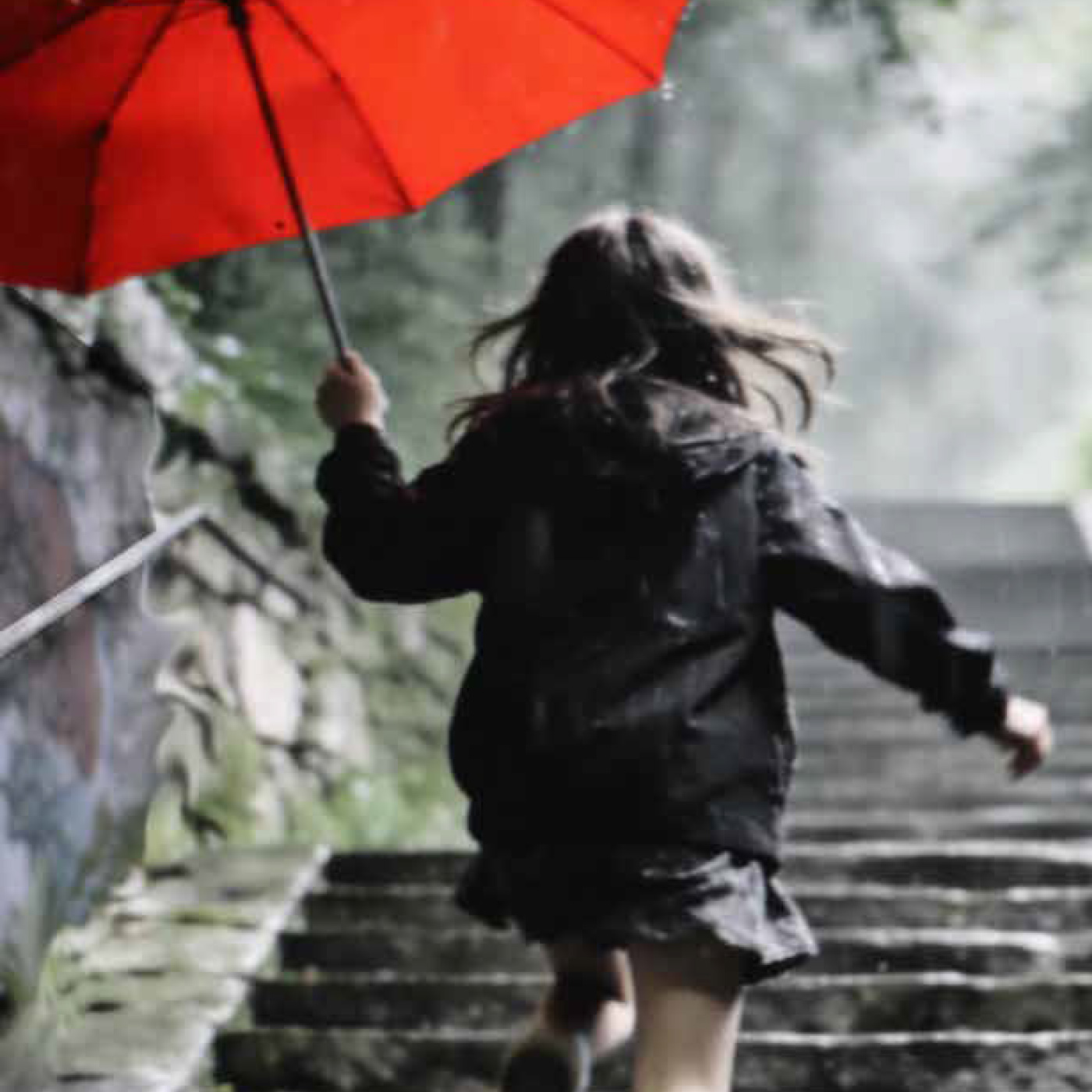 Ein Mädchen mit einem roten Regenschirm springt eine Treppe herauf.