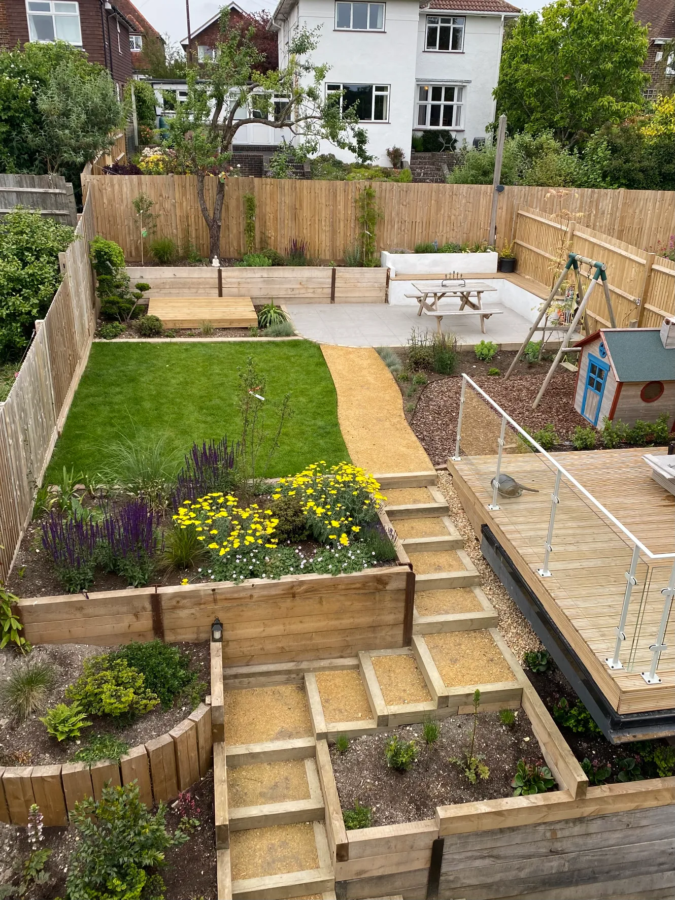 Local stone raised beds in Sussex hillside garden with drought-tolerant planting