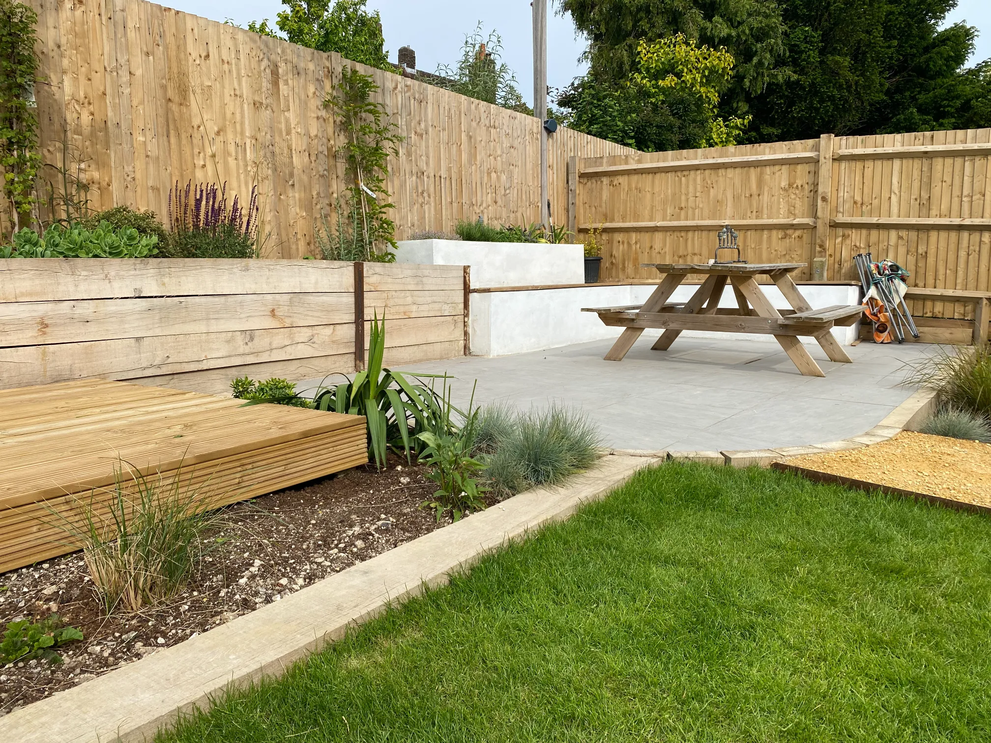 Hot tub area with privacy planting in Sussex hillside garden
