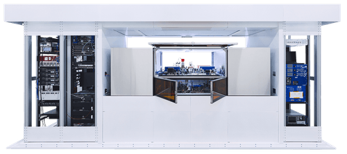 Large white industrial scientific instrument with open central compartment showing complex electronic and mechanical components inside.