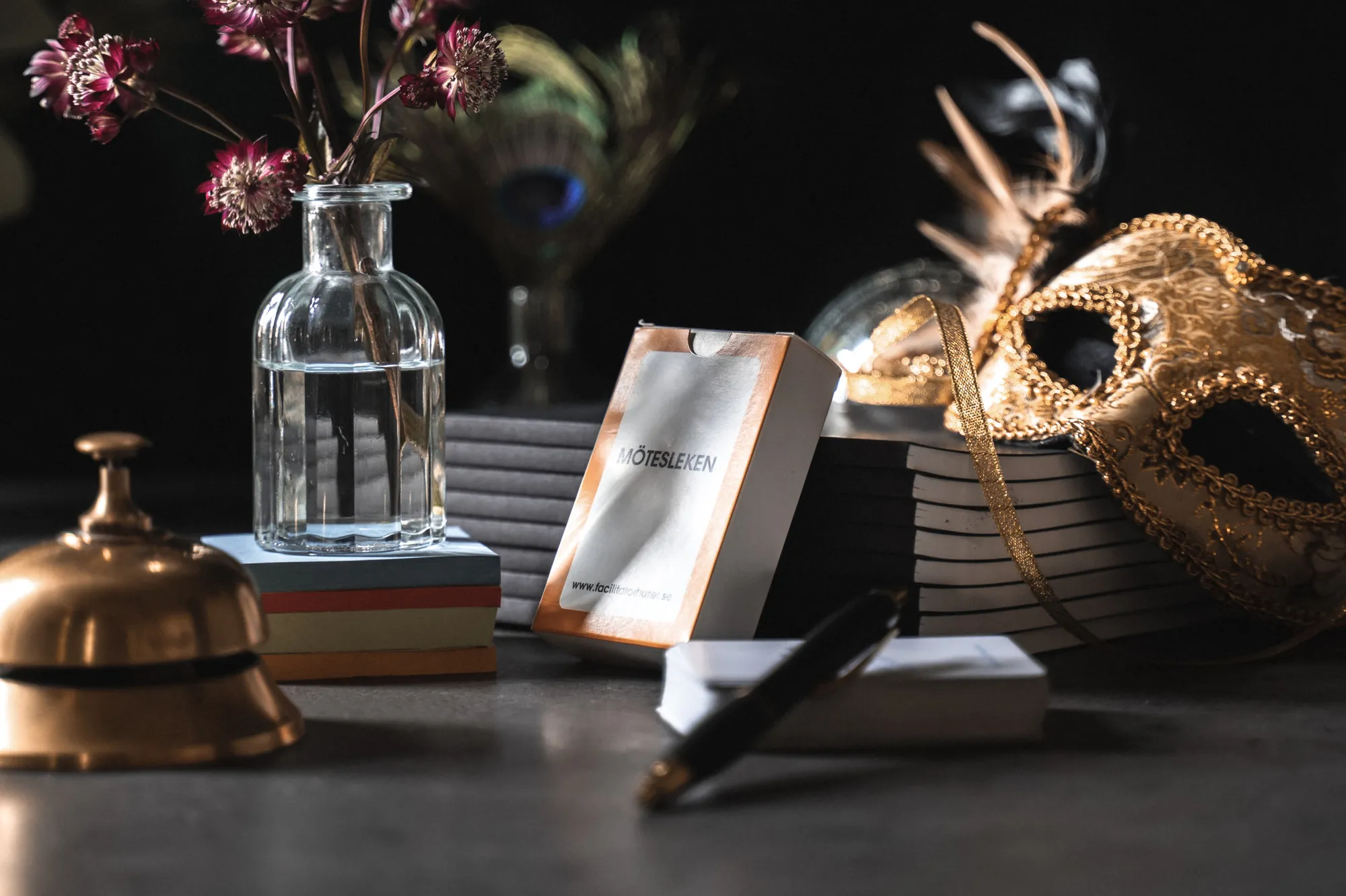 Personer vid bord med vinglas och blommor, socialt mingel.