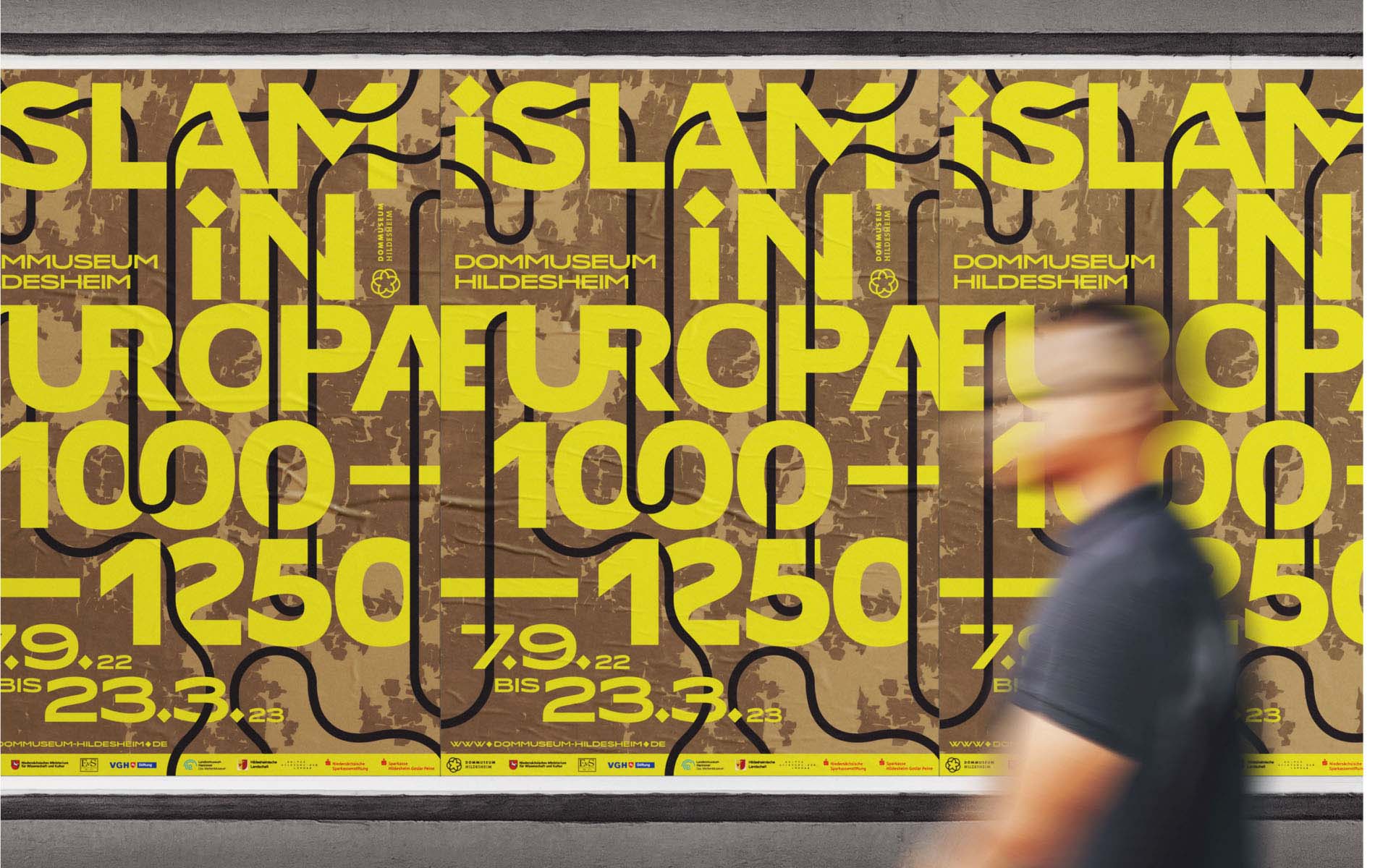 Several exhibition graphic design posters lined up reading "Islam in europa 1000-1250" for Dommuseum Hildesheim with a blurry Person walking in front.