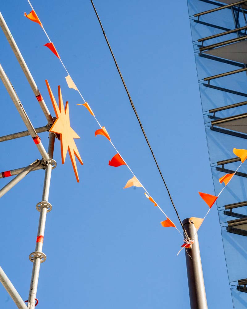 Tiny flags in the Potsdamer Platz brand identity colors aswell as a large cutout shape from the corporate design.