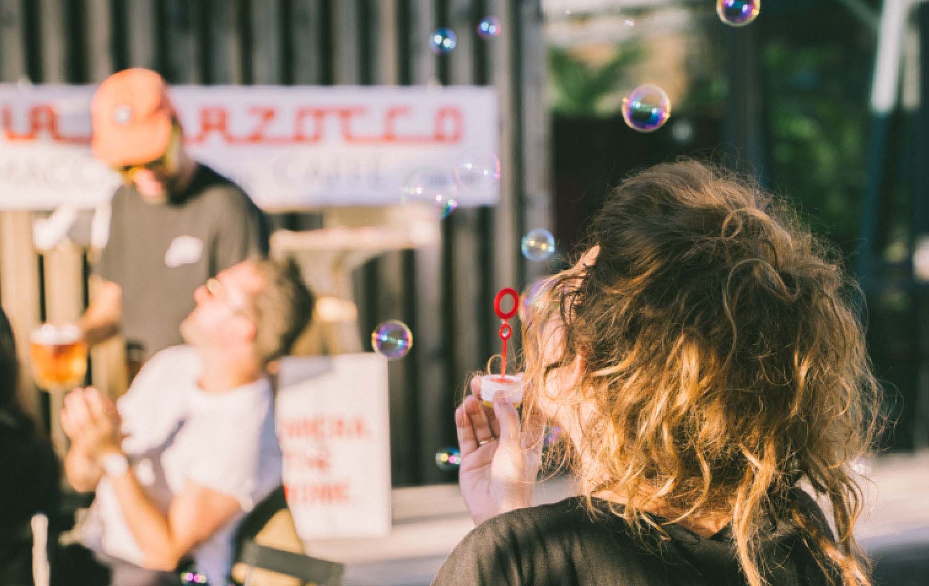 A person blowing soap bubbles during one event of the Coffee Week 