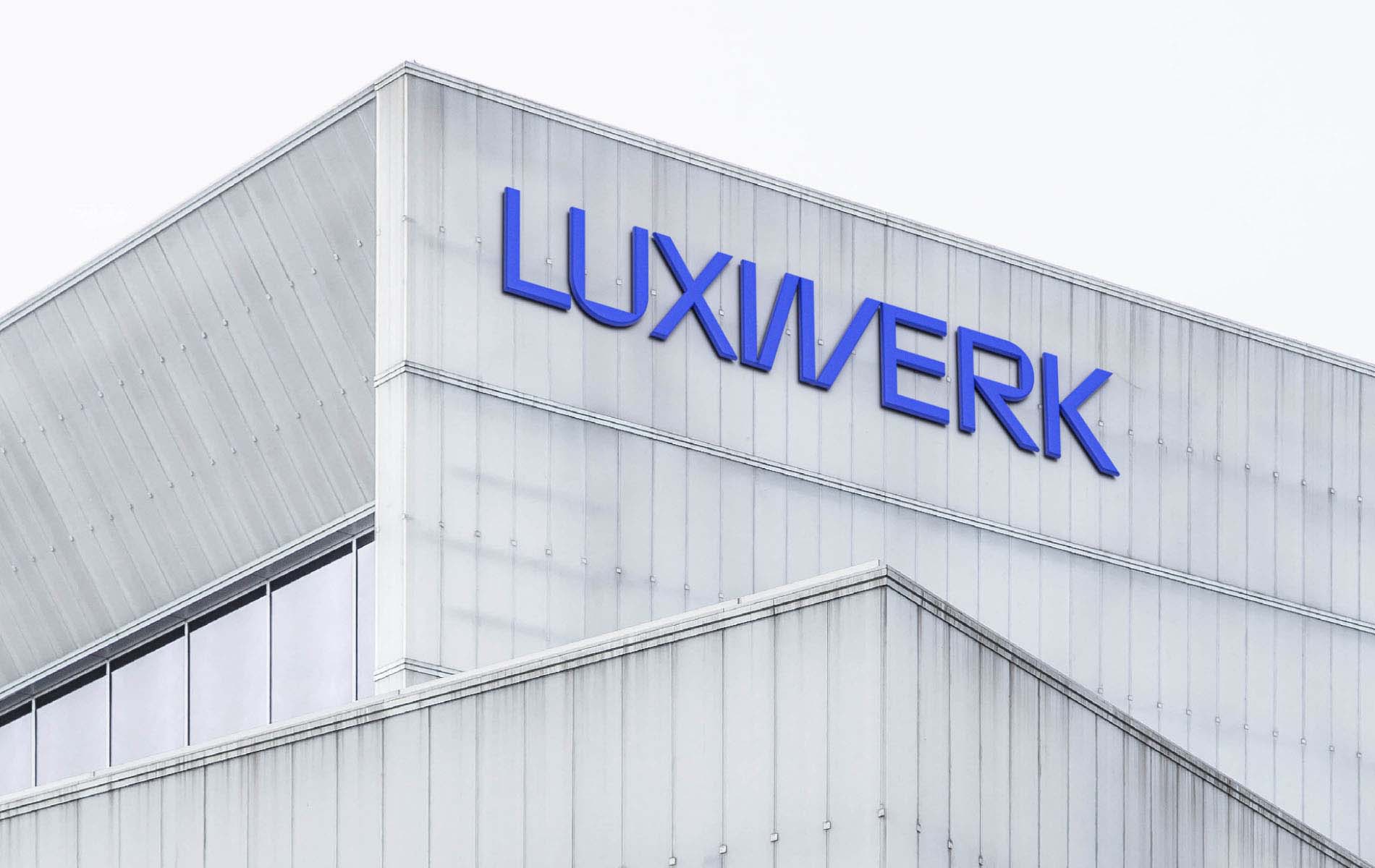 Luxwerk logo design large in a blue colorway on the side of a building.
