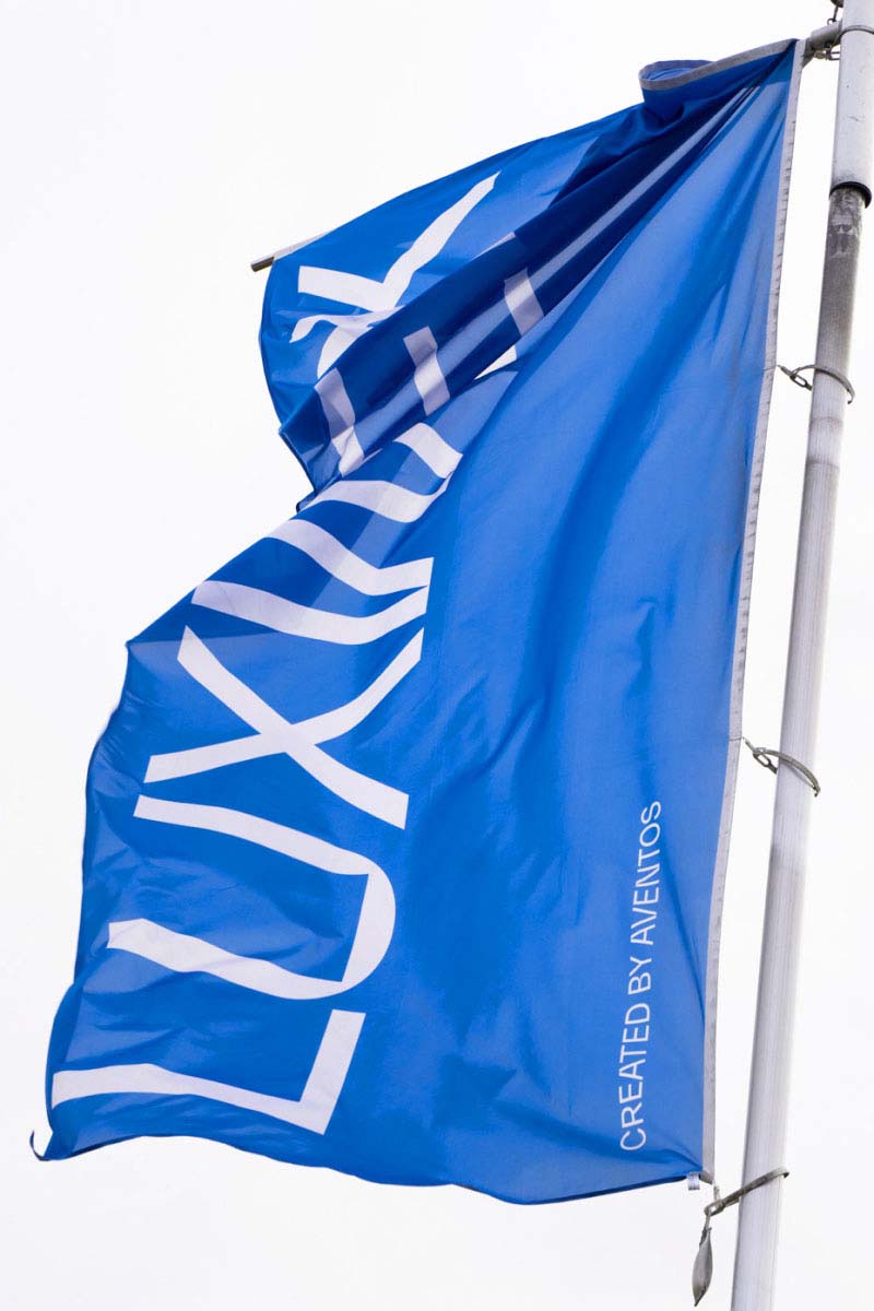 A Luxwerk branded flag in blue with the logo in white, as part of the brand identity design