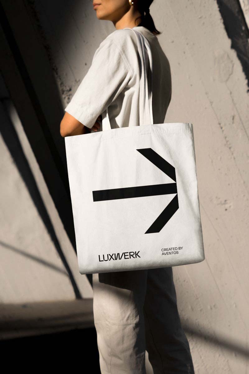 Person wearing totebag with custom Luxwerk arrow symbol and luxwerk logo branding.