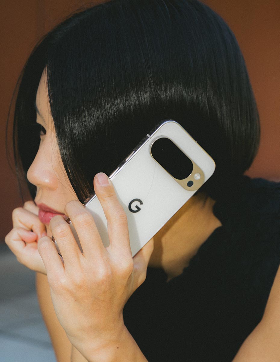 A woman holding a Google Pixel phone to her ear, photographed by a Creative Agency specializing in Branding, Content Creation, and Design Agency services, showcasing minimalistic visual communication.