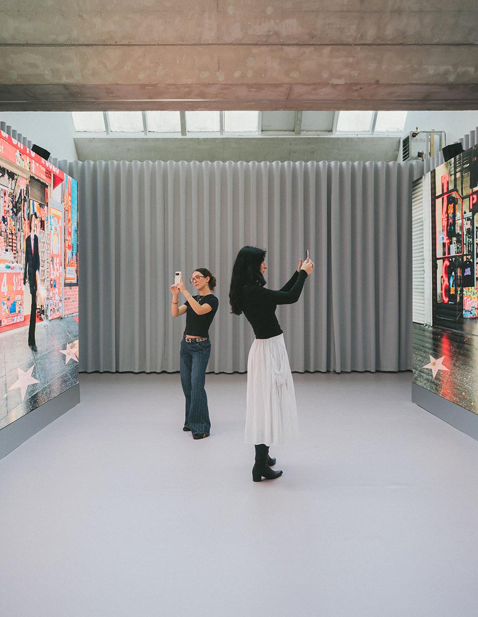 Two women capturing visuals in an immersive gallery space, created by a Design Agency and Creative Agency in Berlin.