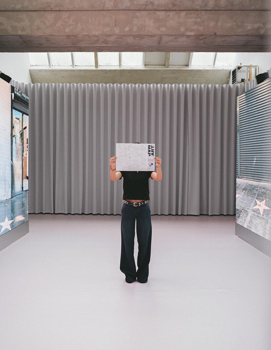 Person holding an art map inside the Kiosque Pixel installation, shot by a Creative Agency focused on Visual Communication and Content Creation.