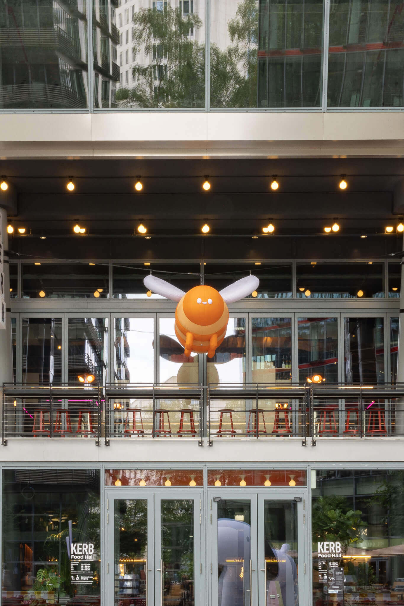 Orange inflatable bee above the food hall entrance, produced for an Event Design project by a Creative Agency.