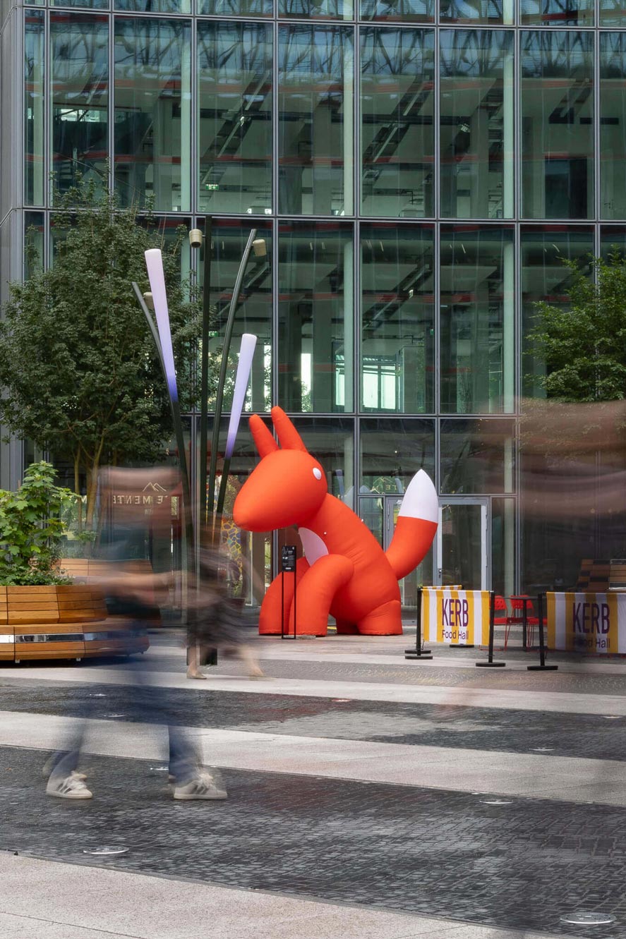 Large red inflatable fox in a modern plaza, showcasing Creative Agency Event Design and Brand Activation.