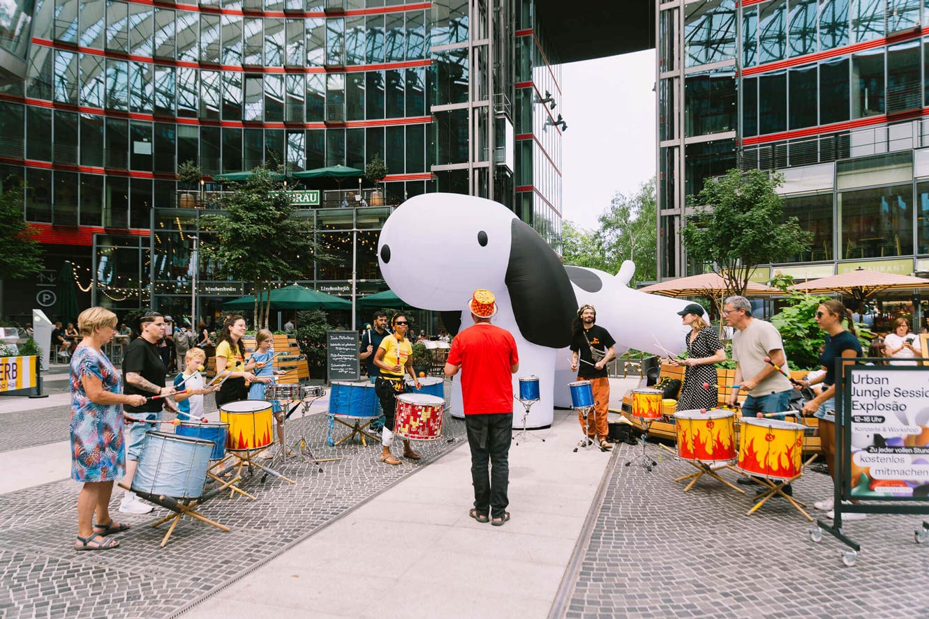 Community drum circle in front of inflatable dog installation at Das Center am Potsdamer Platz, produced as an Event Design activation.