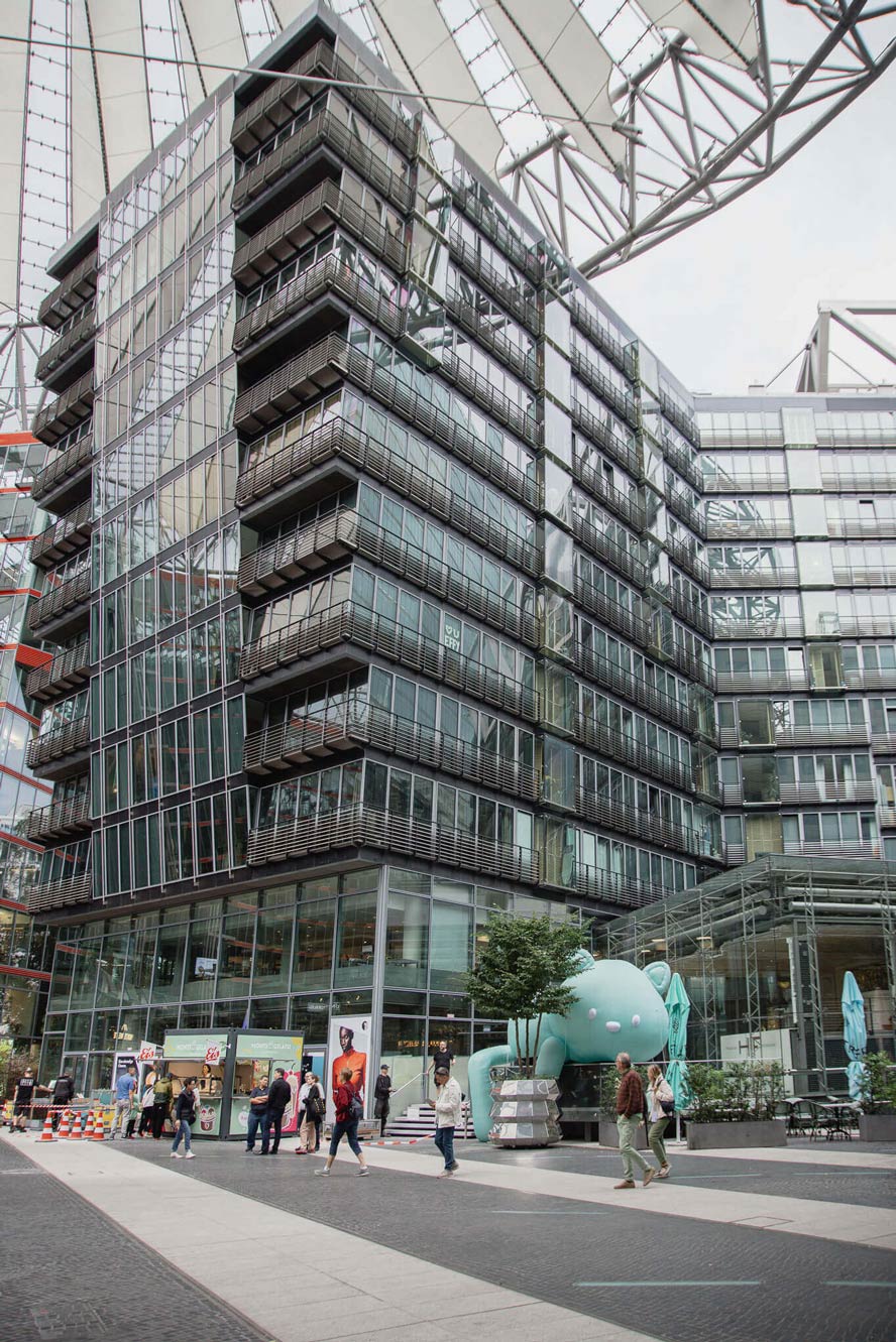 Modern building facade at Das Center am Potsdamer Platz with large turquoise inflatable character, part of a Creative Agency Event Design installation.