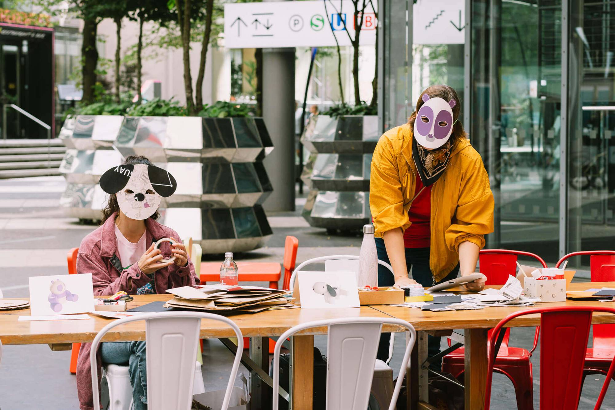People crafting animal masks at an outdoor workshop, produced by a Design Agency for Creative Event Activation.