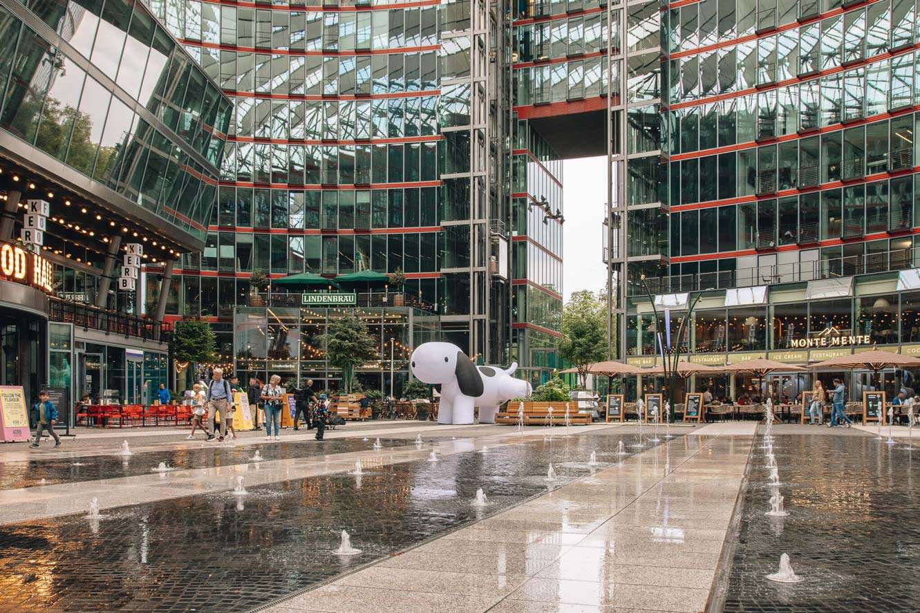 White inflatable dog at Das Center am Potsdamer Platz with water features, part of a Creative Agency’s Brand Experience and Spatial Design.