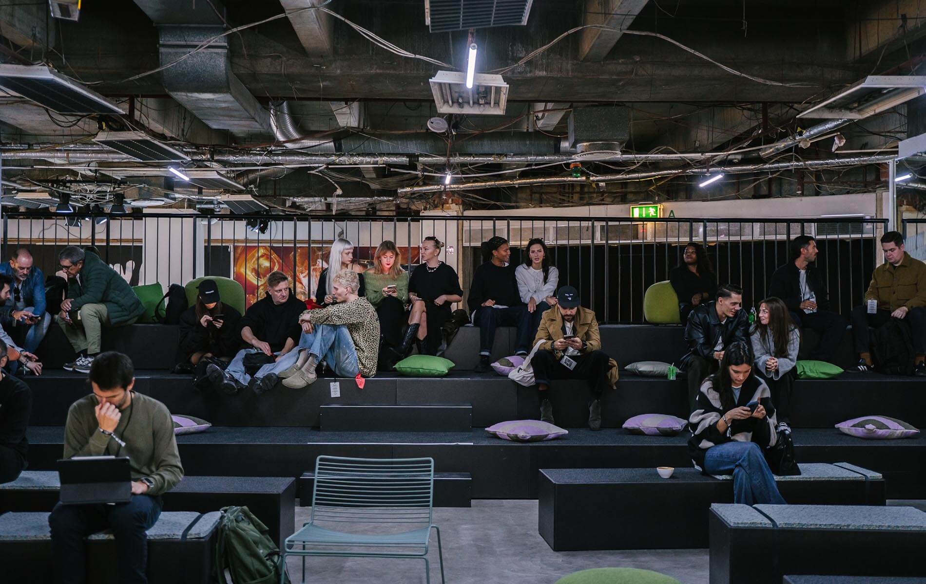 Guests sitting on tiered seating at the Oatly Matcha product launch, captured by a creative agency and design studio in Berlin.
