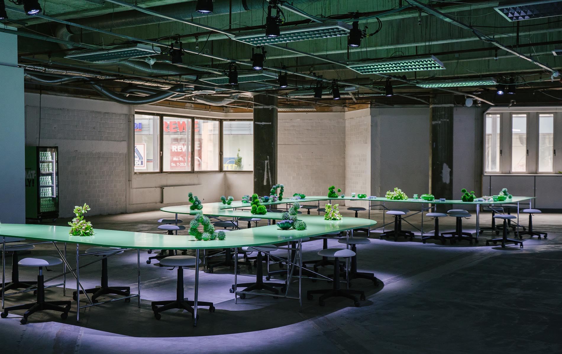 Green tables arranged with sculptural decor for the Oatly Matcha workshop space, documented by a design agency and full-service agency in Berlin.