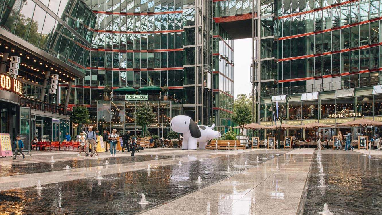 White inflatable dog at Das Center am Potsdamer Platz with water features, part of a Creative Agency’s Brand Experience and Spatial Design.