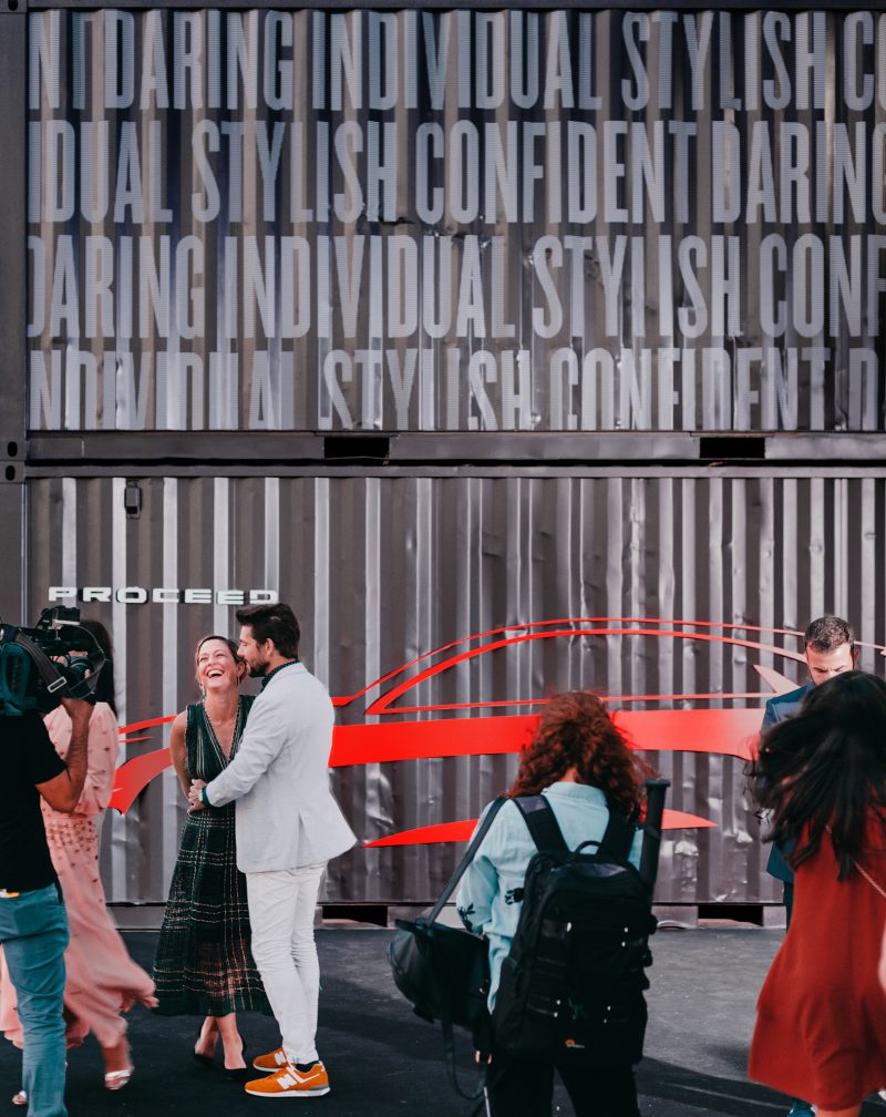 An image of influencers getting their picture taken in front of the KIA launch event design.