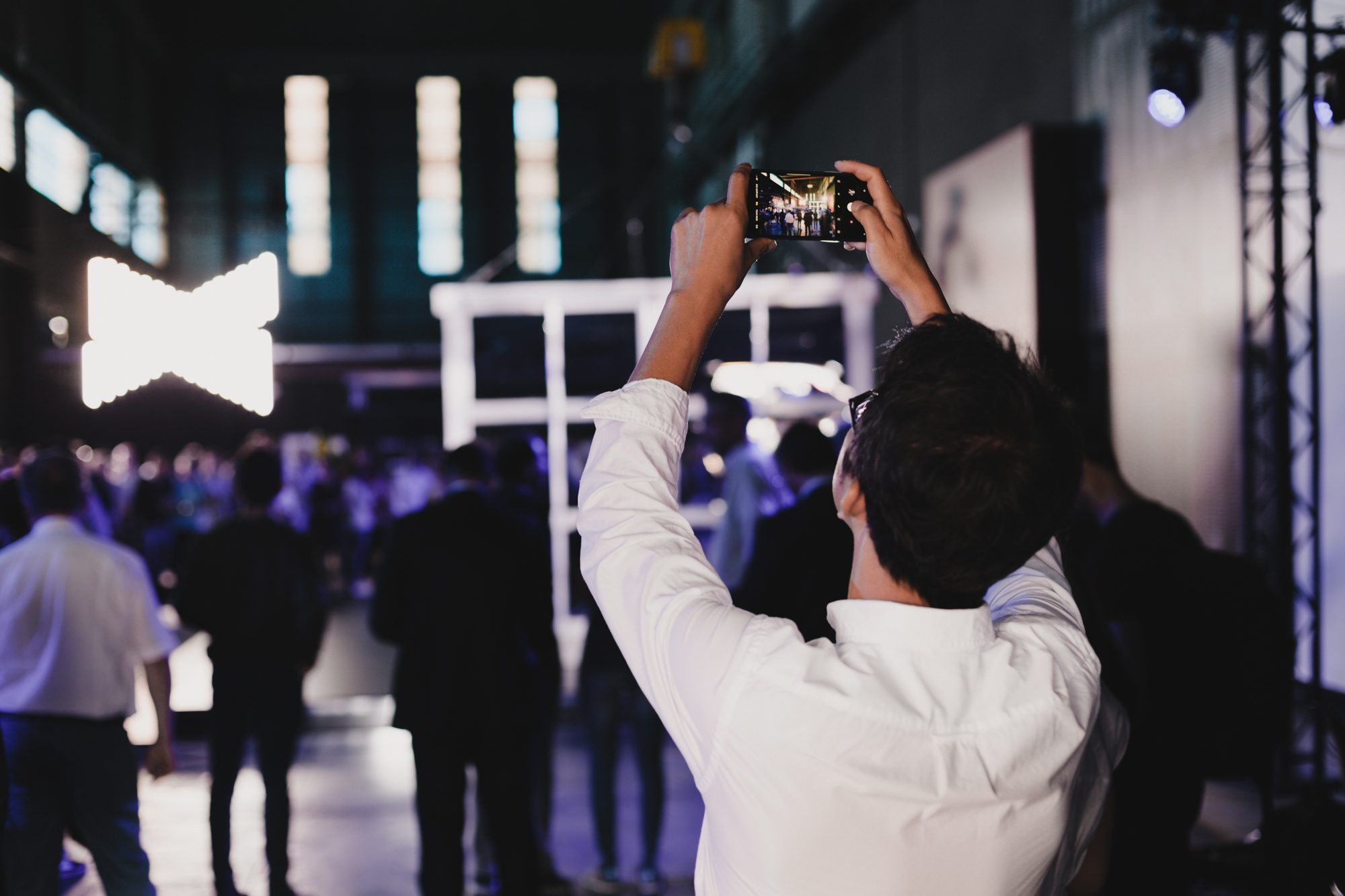 An image of someone taking a picture of a person photographing the KIA launch event design.