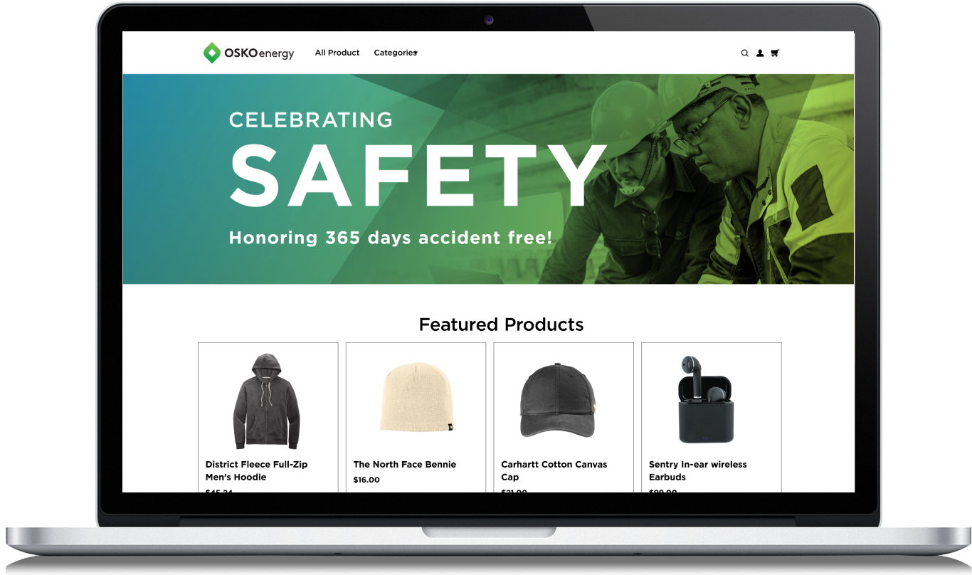 Laptop screen showing OSKO energy website with a safety celebration banner and featured products including a hoodie, beanie, cap, and wireless earbuds.
