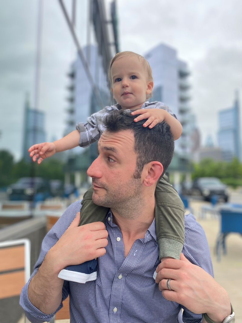 Pastor Designs' founder Richard Pastor with his young son on his shoulders with the Philadelphia skyline behind them.