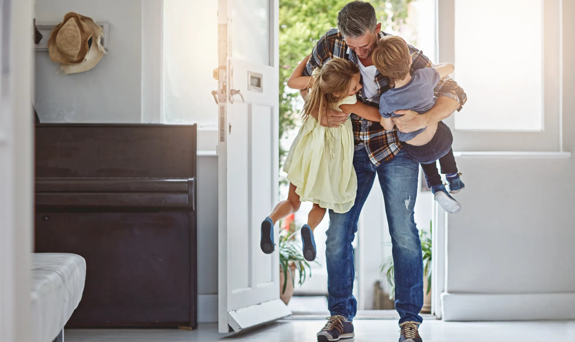 Parent and children arriving home through the front door
