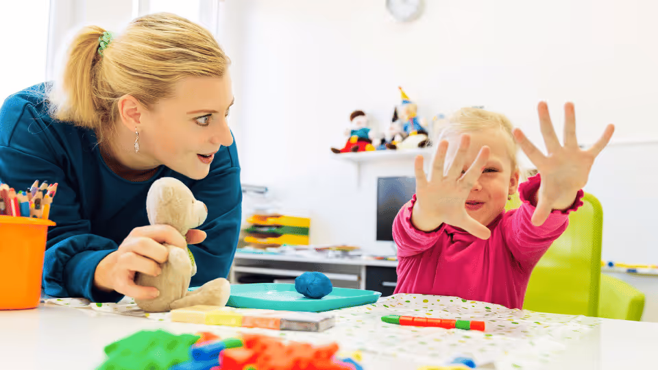 A woman and a child engaged in play, surrounded by various toys, showcasing a moment of joy and connection