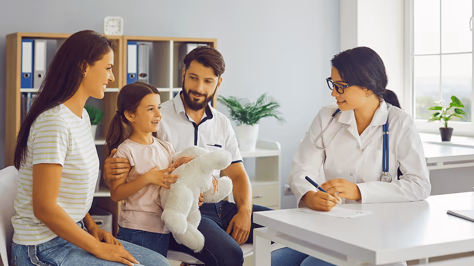 A family consults with a therapist at a desk, discussing health matters in a professional setting.