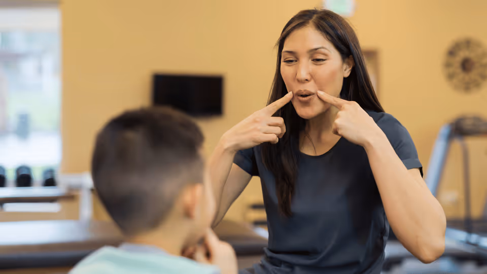 A therapist and a child engage in a speech therapy morning routine.