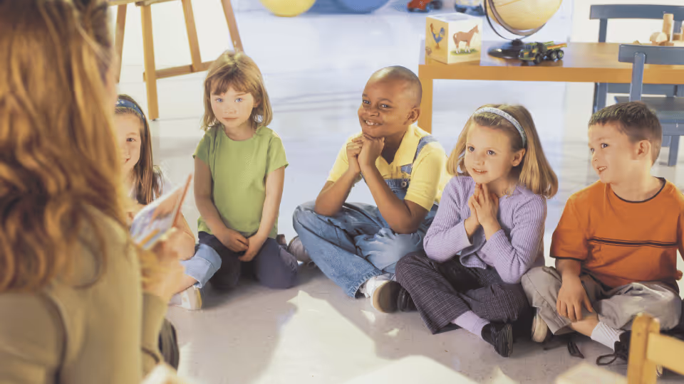 An occupational therapist engages with children in a classroom setting, fostering learning and development through interaction.