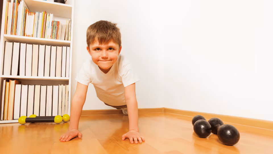  A young boy performing push-ups on the floor, demonstrating strength and determination in his exercise routine