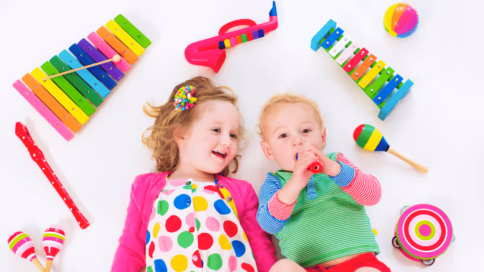 Two children joyfully playing with various musical instruments, showcasing their creativity and love for music.